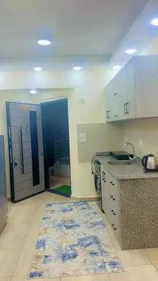 a kitchen with a rug in the middle of a room at Princess Resort 109 B Al Mamsha Al Seyahi in Hurghada