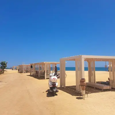 a motor scooter parked on a beach with a building at Princess Resort 109 B Al Mamsha Al Seyahi in Hurghada