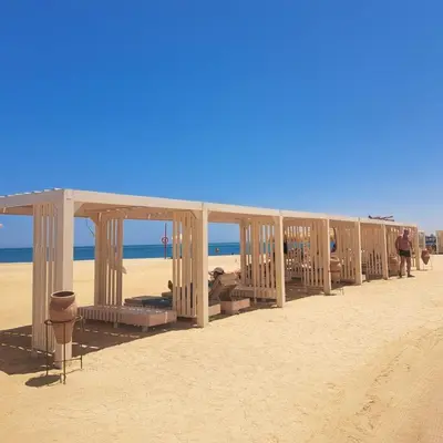 a row of wooden shelters on the beach at Princess Resort 109 B Al Mamsha Al Seyahi in Hurghada