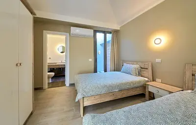 a bedroom with two beds and a bathroom with a sink at Bali 2 BR private pool el gouna heated pool in Hurghada