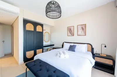 a bedroom with a large white bed with a blue chair at Mangroovy Stays El Gouna - BirdNest in Hurghada