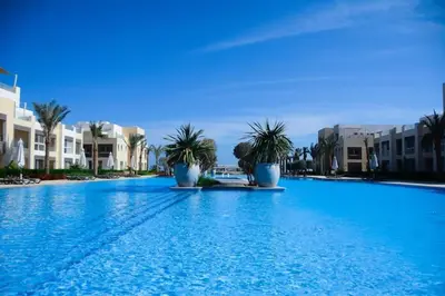 a large swimming pool with palm trees and buildings at mangrovey M9-2B--01 in Hurghada