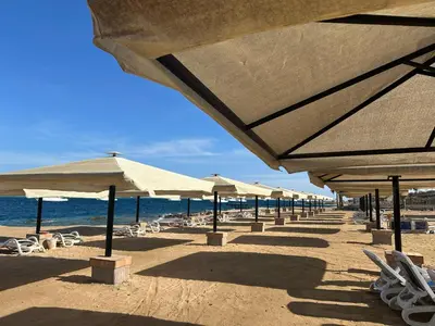 a beach with umbrellas and chairs and the ocean at Beautiful Island View in Hurghada