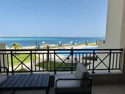 a balcony with a bench and a view of the beach at Beautiful Island View in Hurghada