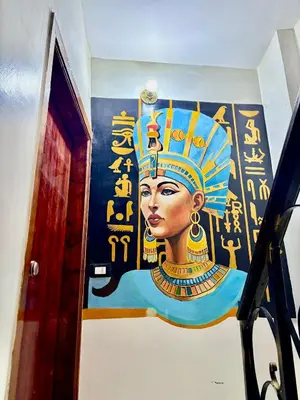 a painting of a woman with a crown on a wall at Al FAHAD private apartments for rent in Luxor