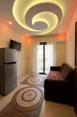 a living room with a couch and a refrigerator at Al FAHAD private apartments for rent in Luxor