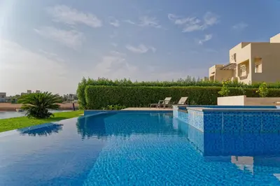a large swimming pool with blue tiles on the side of a house at Luxury Villas in Joubal El Gouna in Hurghada