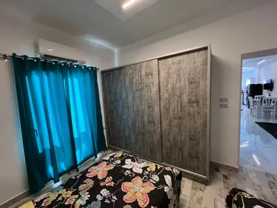 a bedroom with blue curtains and a bed in a room at White House in Hurghada