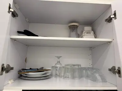 a white cupboard with glasses and plates on it at White House in Hurghada