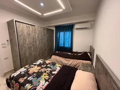 a bedroom with two beds and a window at White House in Hurghada