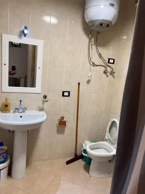 a bathroom with a sink and a toilet and a mirror at ATO luxurious apartments in Hurghada