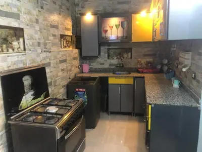 a kitchen with a stove and a stone wall at HAWATY NUBA DWeLL in Nag` el-Ramla