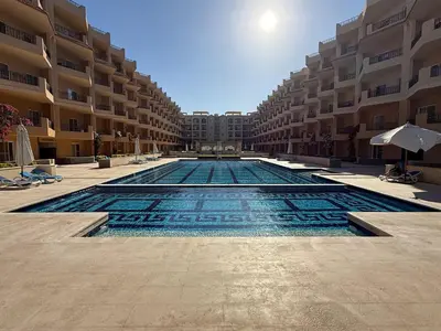 a swimming pool in the middle of a building at Luxury Selena Bay Apartment- Private Beach, Kite School 5 Pools in Hurghada