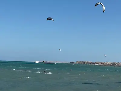 two people are kite surfing in the ocean at Luxury Selena Bay Apartment- Private Beach, Kite School 5 Pools in Hurghada