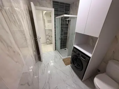 a white bathroom with a washing machine in it at Luxury Selena Bay Apartment- Private Beach, Kite School 5 Pools in Hurghada
