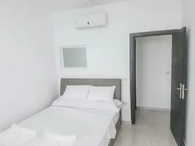 a bedroom with a bed with white sheets and a door at Amazing 2 bedroom apartment with sea view in Hurghada in Hurghada