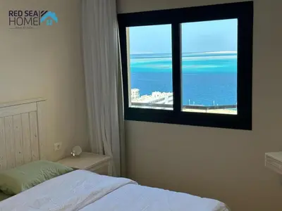 a bedroom with a window with a view of the ocean at Luxury Apartment In The View in Hurghada