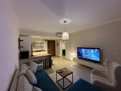 a living room with a couch and a flat screen tv at Luxury Apartment In The View in Hurghada