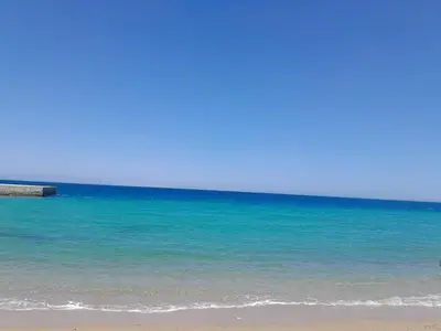 a beach with the blue ocean and a pier at Stylish studio with sea view in Hurghada