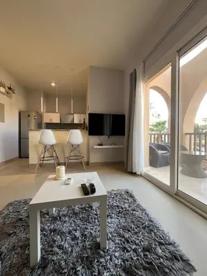 a living room with a table and a large window at El Gouna 1 Bedroom Waterside in Hurghada