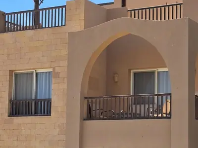 a building with a balcony with chairs on it at El Gouna 1 Bedroom Waterside in Hurghada
