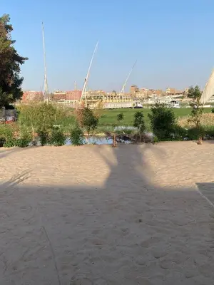 a shadow of a person taking a picture of a stadium at Nile Garden Apartments in Luxor
