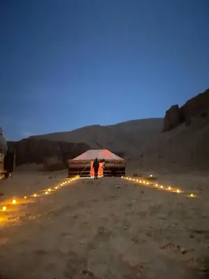 a man standing under a tent in the desert at night at Life in Luxor in Nag` Naqsha