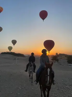 two people riding horses and hot air balloons at Life in Luxor in Nag` Naqsha