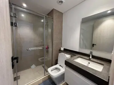 a bathroom with a shower and a toilet and a sink at Kamaran 2BR • Luxurious Retreat in Hurghada