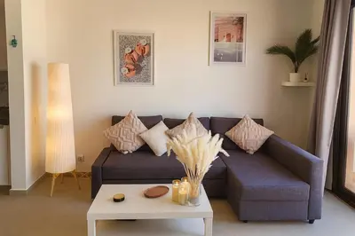 a living room with a couch and a table at Duplex 1BR King Bed and1 Sofa Bed By the Pool in Hurghada