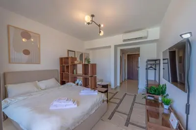 a bedroom with a large bed and a tv at The Contemporary Condo in Gouna in Hurghada