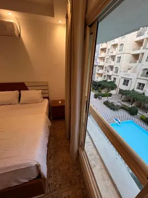 a hotel room with a bed and a view of a pool at Luxury One Bed Room Apartment in Hurghada