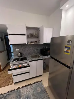 a kitchen with a stainless steel refrigerator and white cabinets at Luxury One Bed Room Apartment in Hurghada