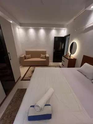 a bedroom with a large bed and a couch at Luxury One Bed Room Apartment in Hurghada