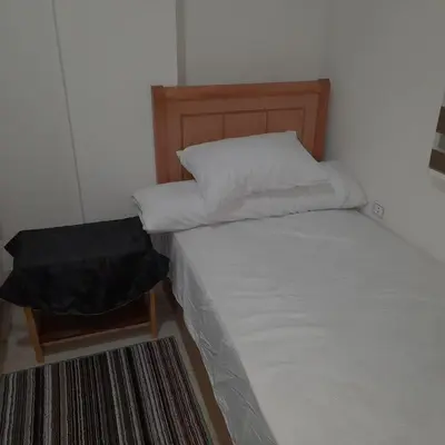 a bed with white sheets and a wooden headboard at الغردقة الانتر in Hurghada