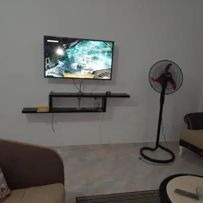 a living room with a fan and a flat screen tv at الغردقة الانتر in Hurghada