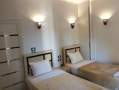 two beds in a room with lights on the wall at Rayan Nubian Guest House in Aswan