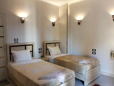 two beds in a room with lights on the wall at Rayan Nubian Guest House in Aswan