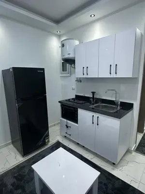 a kitchen with white cabinets and a black refrigerator at Central Hurghada Studios in Hurghada