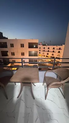 a table and two chairs on a balcony with a building at Central Hurghada Studios in Hurghada
