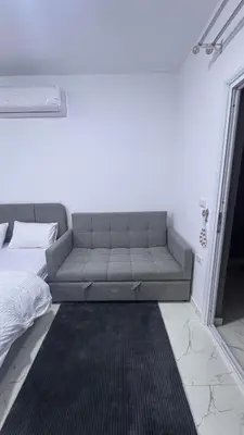 a gray couch in a room with a bed at Central Hurghada Studios in Hurghada