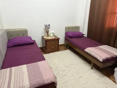 two beds in a room with purple sheets and a table at Hurghada cozy apartment in Hurghada