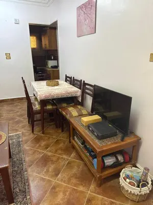 a dining room with a table and a television at Hurghada cozy apartment in Hurghada