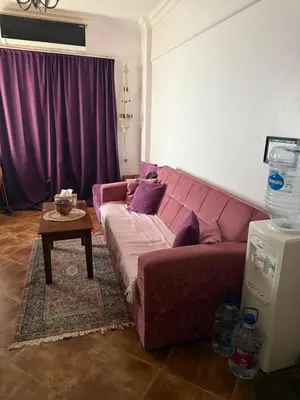 a living room with a pink couch and a table at Hurghada cozy apartment in Hurghada