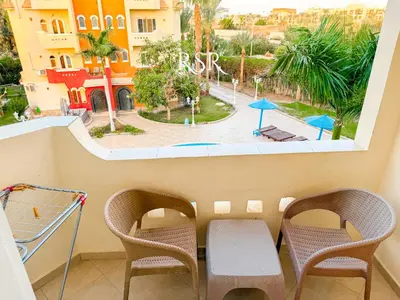 a balcony with chairs and a view of a park at Apartment with a private roof top , pool , Garden in Hurghada