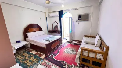 a small bedroom with a bed and a window at Family Flat With Breakfast in Luxor