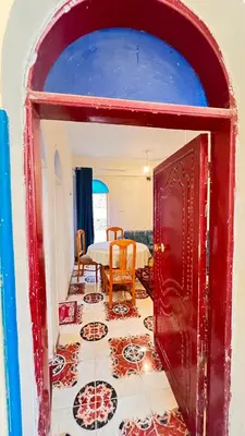 a room with a red door and a table at Family Flat With Breakfast in Luxor