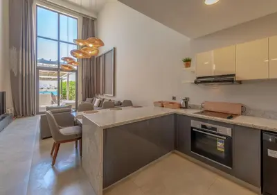 a kitchen with a counter and a living room at Prime 4BR Villa in Ancient Sands, El Gouna Private Swimming Pool & Lagoon Access in Hurghada