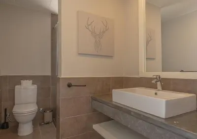 a bathroom with a sink and a toilet and a mirror at Prime 4BR Villa in Ancient Sands, El Gouna Private Swimming Pool & Lagoon Access in Hurghada