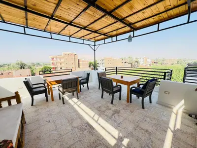 a patio with tables and chairs on a roof at Villa Pure Luxor in Luxor